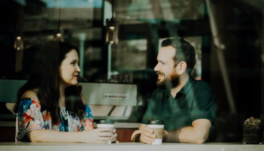 Man and woman in a coffee shop talking.